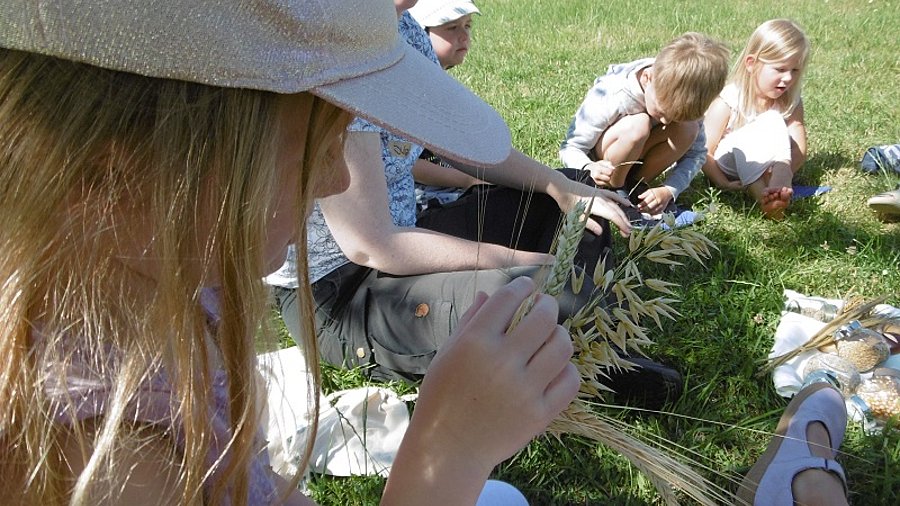 Kinder und Jugendliche sitzen auf einer Wiese