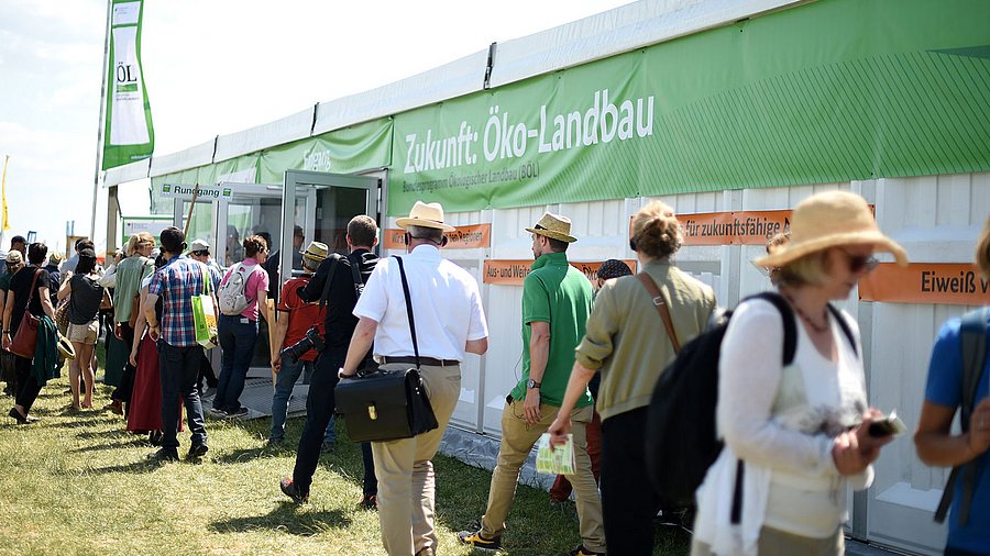 Menschen vor dem Eingang eines Messezeltes.