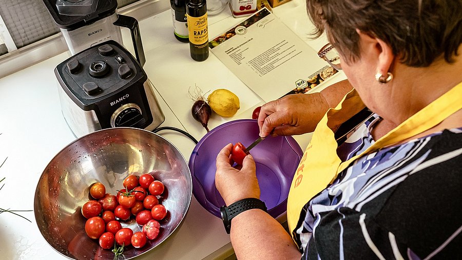 Eine Frau schneidet Tomaten klein