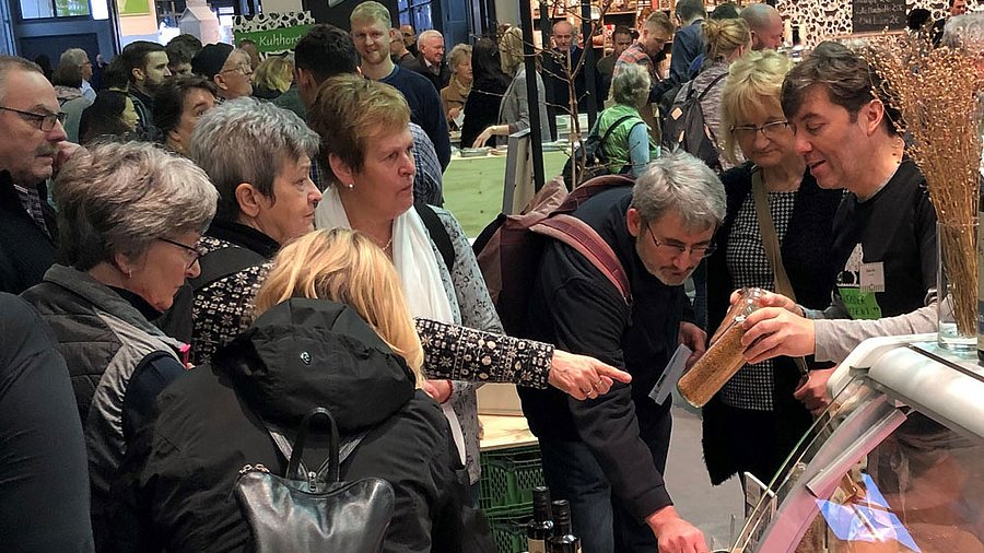 Menschen stehen an einem Messestand